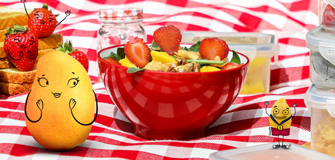 Cerealdo al lado derecho, mango y fresas lo ven desde el lado izquierdo, ensalada de frutas en la parte central.